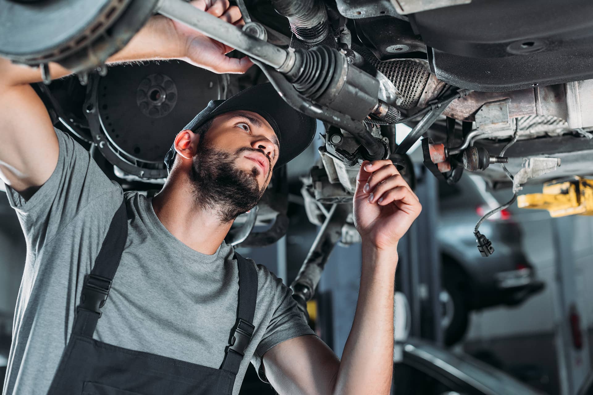 A mechanic repairing under a trailer truck.
