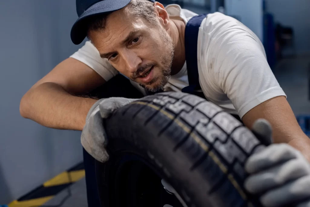 A man focusing on checking his tire.