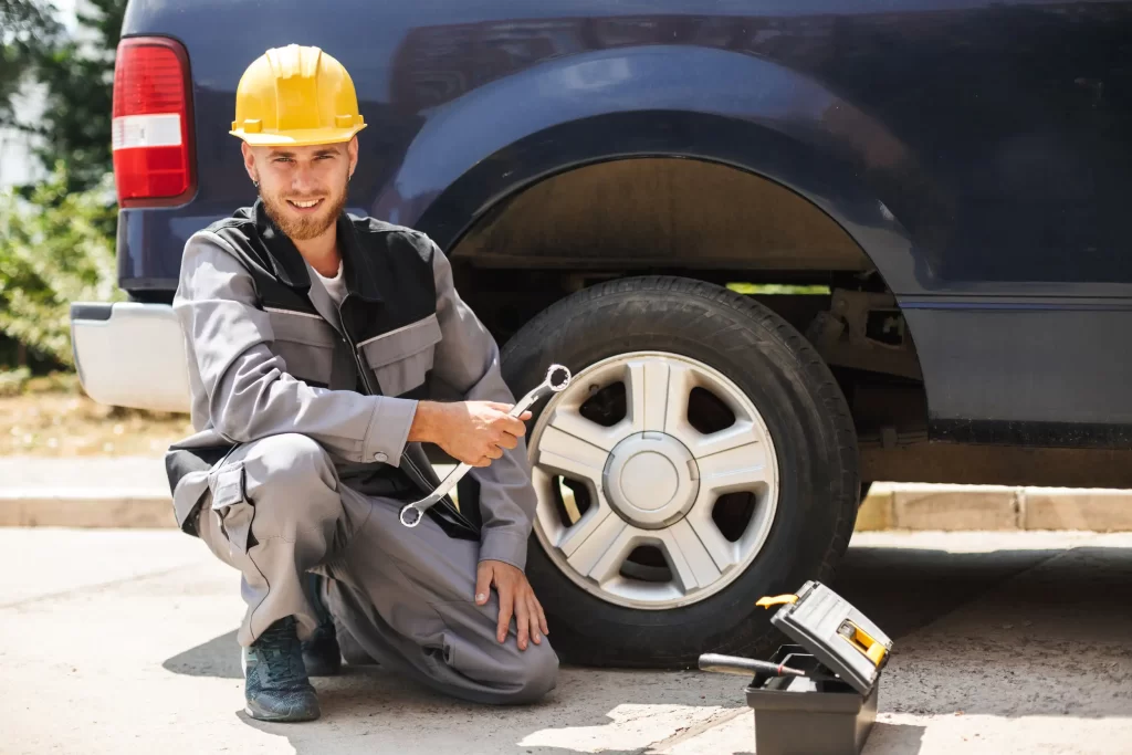 A man ready to fix the car tire with his tools.