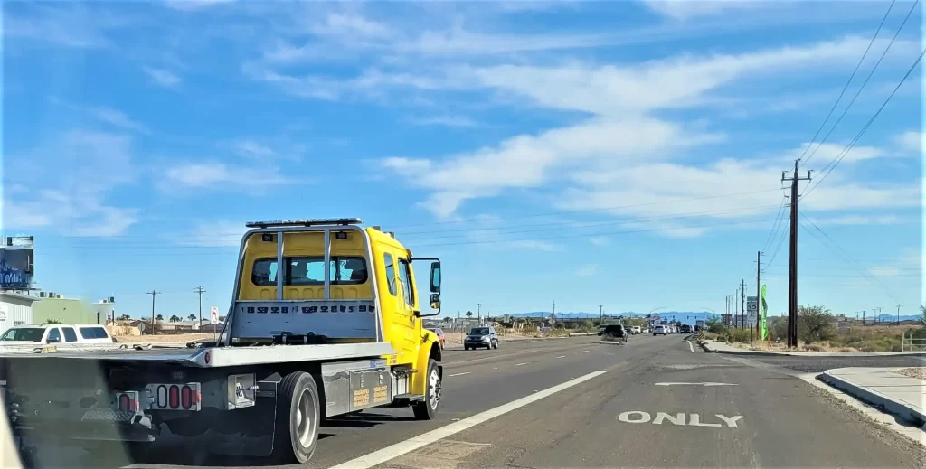 Yellow roadside assistance truck on the way to assist a stranded driver.