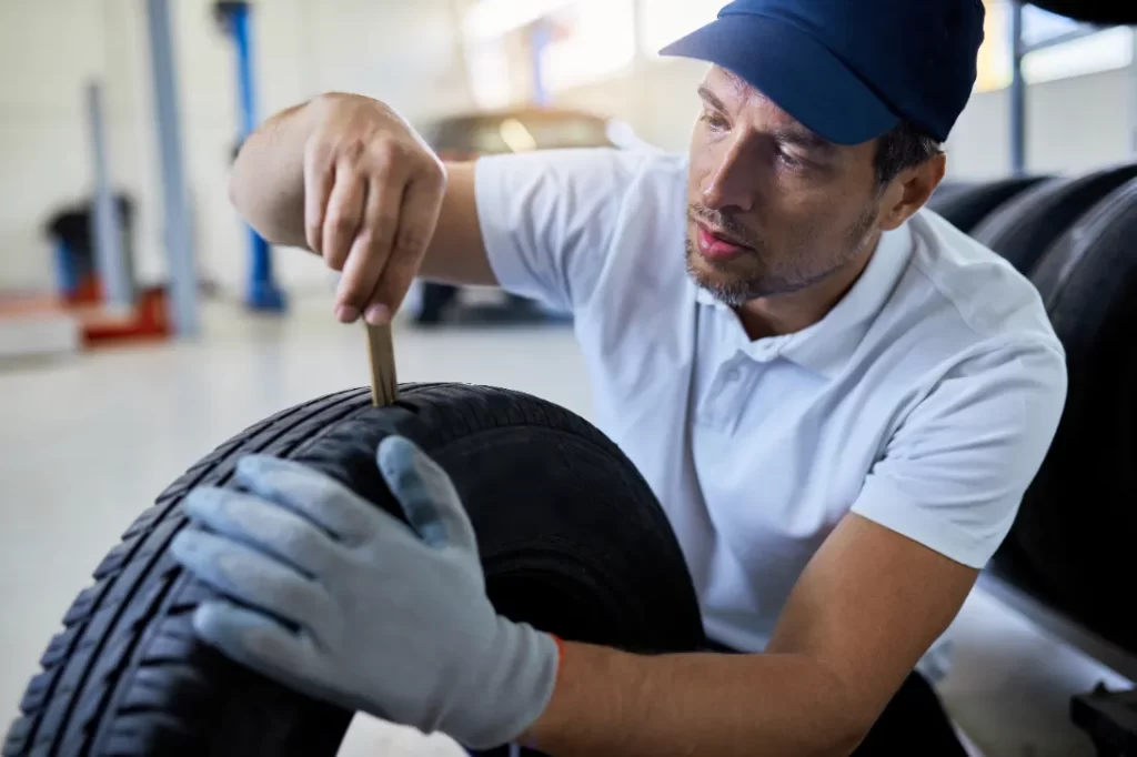 A man checking and measuring the tire before repairing.