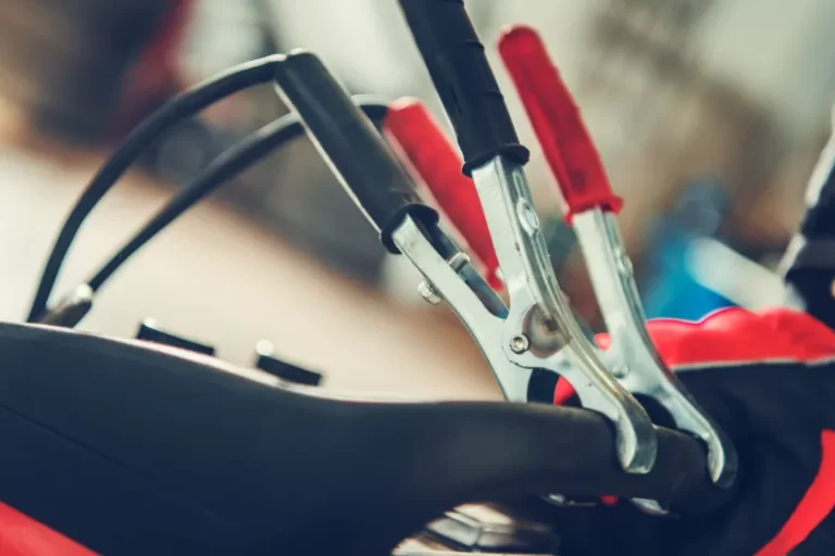 Close-up of jumper cables being connected for vehicle jumpstarts.
