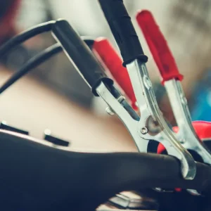 Close-up of jumper cables being connected for vehicle jumpstarts.