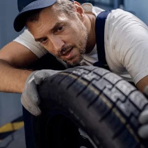 A man focusing on checking his tire.