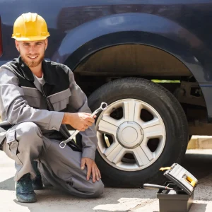 A man ready to fix the car tire with his tools.