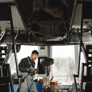 A technician checking for problems and damages of the truck suspensions.