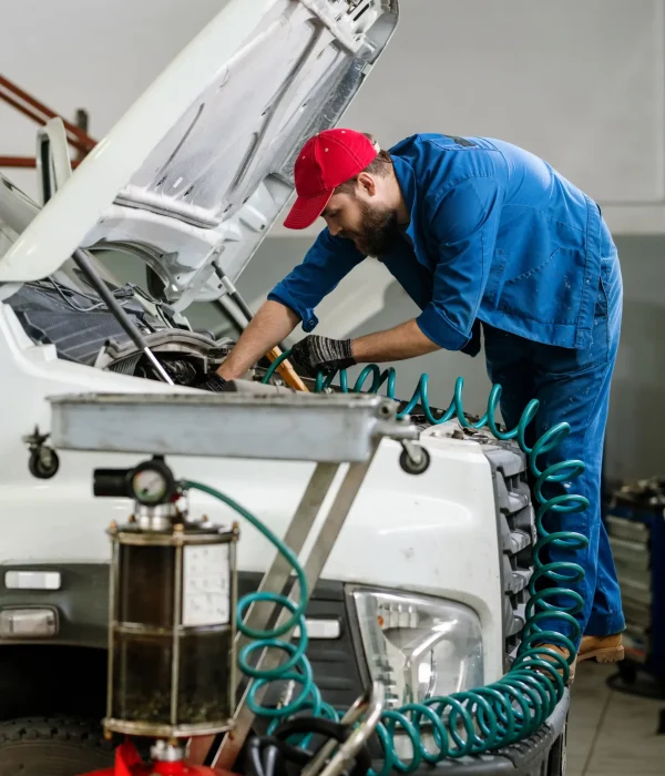 An image of a uniformed mechanic checking the valve with a device for system error.